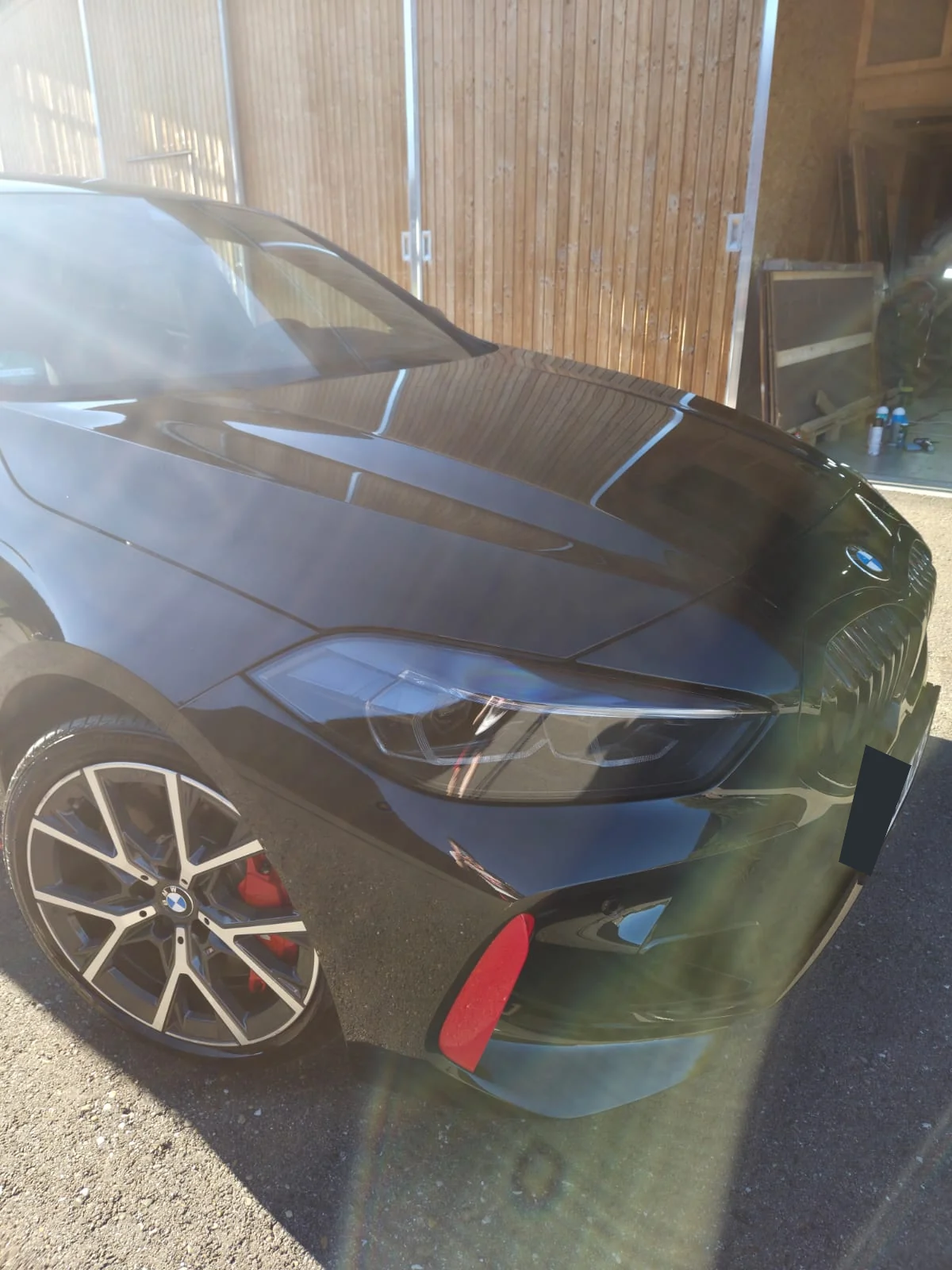 Glänzende Frontpartie eines schwarzen BMW nach der Lackpolitur